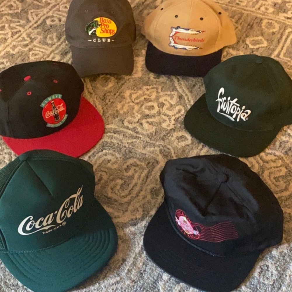 6 baseball caps. Bass Pro Shop.  Coca-Cola. Thunderbirds. Fruitopia.